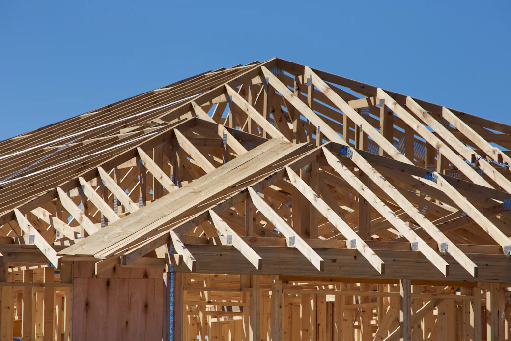 Stock photograph: roof trusses and wall framing on a new house under construction.